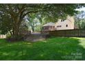 Expansive backyard featuring a large deck, mature trees, and a wooden privacy fence at 6008 Corkstone Dr, Mint Hill, NC 28227