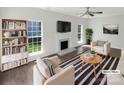 Bright living room with fireplace, neutral decor, and hardwood floors is virtually staged for a modern look at 704 Georgie St, Troutman, NC 28166