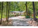 Charming home with gravel driveway surrounded by mature trees and natural landscaping at 7230 Ridge Lane Rd, Charlotte, NC 28262