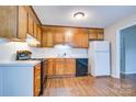 Functional kitchen featuring wood cabinetry, a black range, and laminate floors for a cozy feel at 817 32Nd Street Ne Dr, Conover, NC 28613