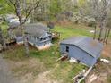 Exterior view of the back of the house, deck, outbuildings and mature trees at 9216 Caycee Dr # 32, Davidson, NC 28036
