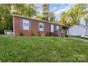 Cozy brick home with neat landscaping, highlighted by gray shutters and a convenient front entrance with welcoming sign at 1131 Laurel St, Salisbury, NC 28144