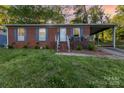 Charming brick home featuring a welcoming front porch and a convenient covered carport, all set on a lush lot at 1131 Laurel St, Salisbury, NC 28144