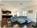 Inviting living room featuring a plush blue sectional sofa, wood floors, and an open floor plan at 12421 Fiorentina St, Charlotte, NC 28277