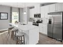 Stylish kitchen with white cabinets, stainless appliances, and a center island with barstool seating at 1358 Holden Sw Ave, Concord, NC 28025