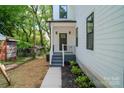 Inviting front porch with black door, white railings, and landscaped garden at 1413 Hateras Ave, Charlotte, NC 28216