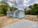 Light blue single-story home featuring vinyl siding, white trim, and a gravel parking area at 171 Three Cs Rd, Kershaw, SC 29067