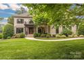 Charming two-story brick home with a well-manicured lawn, lush landscaping, and a welcoming entrance at 18618 Rollingdale Ln, Davidson, NC 28036