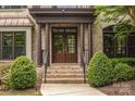 Close-up of the home's entrance, showcasing a beautiful brick facade, stately columns, and lush landscaping at 18618 Rollingdale Ln, Davidson, NC 28036