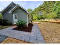 The backyard features a quaint wooden deck and a landscaped walkway with stone pavers at 213 Meadow Wind Ct, Monroe, NC 28110