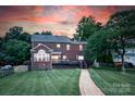 Brick home featuring a well-maintained lawn, a spacious deck, a brick walkway, and mature trees at 220 Chandeleur Dr, Mooresville, NC 28117