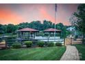 Lakeside property with a double dock, a manicured lawn, mature trees, and a brick walkway at 220 Chandeleur Dr, Mooresville, NC 28117