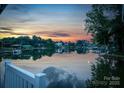 Scenic water view featuring a calm lake, residential waterfront homes, and a colorful sunset at 220 Chandeleur Dr, Mooresville, NC 28117