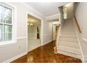 Bright foyer with hardwood floors, a staircase, and views into the dining and living areas at 3005 Kenninghall Ct, Charlotte, NC 28269