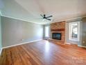 Hardwood floor living room featuring a brick fireplace, natural light and neutral wall colors at 3530 Farm Lake Sw Dr, Concord, NC 28027