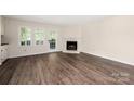 Spacious living room with a fireplace, natural light, and wood flooring at 3625 Colony Crossing Dr, Charlotte, NC 28226