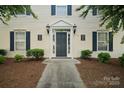 Charming building entrance with a well-lit doorway and manicured shrubbery at 3849 Carl Parmer Dr, Harrisburg, NC 28075