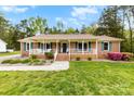 Charming brick ranch home with covered porch, green shutters, landscaping, and a well-maintained front yard at 504 Ogden Dr, Gastonia, NC 28056