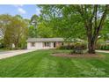 Landscaped front yard featuring a mature tree, trimmed lawn, and charming curb appeal at 5211 Driftwood Dr, Davidson, NC 28036