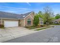 Suburban home with a two-car garage, stone accents, and landscaping, situated on a tree-lined street at 6311 Ridge Path Ln, Charlotte, NC 28269