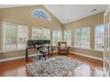 Well-lit office space with a desk, ergonomic chair, patterned rug, and ample natural light from multiple windows at 6311 Ridge Path Ln, Charlotte, NC 28269