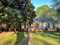 Inviting brick home featuring well-maintained lawn, mature trees, and classic shutters, enhancing the exterior charm at 729 Aintree Rd, Charlotte, NC 28215