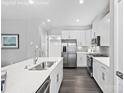 Modern kitchen featuring white cabinets, stainless steel appliances, and a large island with a sink at 7349 Childress Sw Dr, Concord, NC 28025