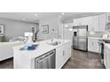 Modern kitchen featuring white cabinets, stainless steel appliances, and a large island with a sink at 7349 Childress Sw Dr, Concord, NC 28025