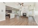 Open-concept living room featuring a fireplace, ceiling fan and hardwood floors at 740 Rosegate Dr, Gastonia, NC 28056