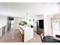 Bright, open kitchen with a waterfall island, modern pendant lighting, stainless steel appliances, and light wood floors at 7507 Limerick Dr, Charlotte, NC 28270