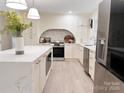 Modern kitchen with stainless steel appliances, a large island, white cabinets, and a stylish backsplash at 7507 Limerick Dr, Charlotte, NC 28270