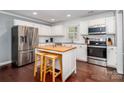 Bright kitchen featuring stainless steel appliances, white cabinets, and a butcher block island at 8807 Tree Haven Dr, Charlotte, NC 28270