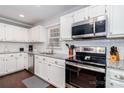 Well-equipped kitchen with granite countertops, white cabinets, and modern appliances at 8807 Tree Haven Dr, Charlotte, NC 28270