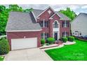Attractive two-story brick home with an attached garage and landscaped front yard at 9001 Fenwick Dr, Indian Trail, NC 28079