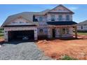 New two-story home featuring an attached two car garage and covered front porch in a residential area at 1015 Gardenia Dr # 52, Mt Ulla, NC 28125