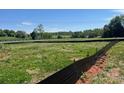 A grassy open lot with potential for a new build, bordered by trees and a black fence line at 1015 Gardenia Dr # 52, Mt Ulla, NC 28125
