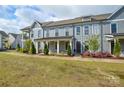 Inviting exterior view of a townhome with a covered front porch and well-maintained lawn at 10209 Meeting House Nw Dr, Huntersville, NC 28078