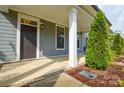 Cozy front porch of a townhome with sturdy columns, well-kept landscaping, and a welcoming entryway at 10209 Meeting House Nw Dr, Huntersville, NC 28078