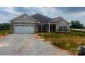 Charming single Gathering home with a two-car garage, stone accents and durable gray siding at 1035 Gardenia Dr # 51, Mt Ulla, NC 28125