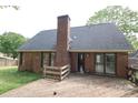 Rear exterior view featuring a brick chimney and wooden deck at 1121 Thoroughbred Nw Pl, Concord, NC 28027