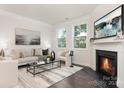 Well-lit living room with modern furnishings, including a fireplace, flanked by windows, and refined decor at 114 S Shayna Rd, Troutman, NC 28166