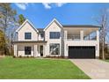 Beautiful two-story modern farmhouse featuring a black garage door and spacious front lawn at 13453 Portside Ln, Lancaster, SC 29720