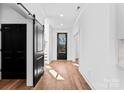 Hallway with wood floors, white walls, and black door accents, creating a modern feel at 13453 Portside Ln, Lancaster, SC 29720