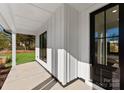 Covered porch with white trim and black accents, offering an inviting outdoor space at 13453 Portside Ln, Lancaster, SC 29720