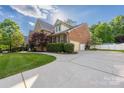 Spacious home featuring a long driveway, well-maintained lawn, and brick exterior at 15024 Old Vermillion Dr, Huntersville, NC 28078