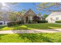Beautiful home featuring a well-manicured lawn, brick facade, and lush landscaping at 15024 Old Vermillion Dr, Huntersville, NC 28078