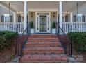 Inviting front entrance with brick steps, manicured shrubs, and charming lanterns flanking the door at 15323 Barnsbury Dr, Huntersville, NC 28078