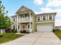 Inviting two-story home featuring a double porch, lovely landscaping, and a convenient two-car garage at 15747 Reynolds Dr, Indian Land, SC 29707