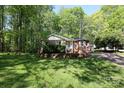 Quaint brick house nestled among mature trees, enhanced by a lovely green lawn and a welcoming facade at 1730 Deer St, Charlotte, NC 28214