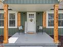 Close-up of front porch with chairs, 'Welcome' sign, wood columns, and decorative door wreath at 2222 Moose Rd, Kannapolis, NC 28083